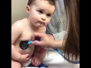 Sweet baby boy rests head on nurse's hand